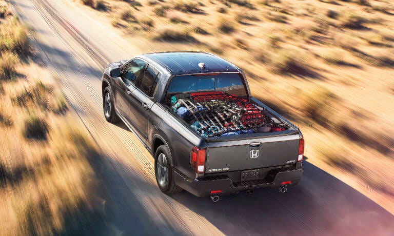 2025 Honda Ridgeline driving with cargo in bed