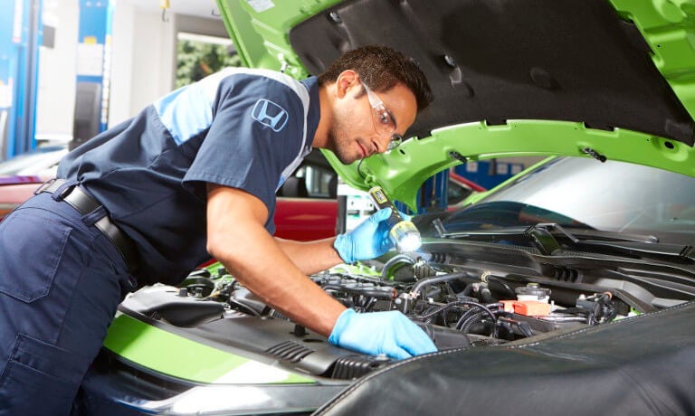 Honda technician checking under hood