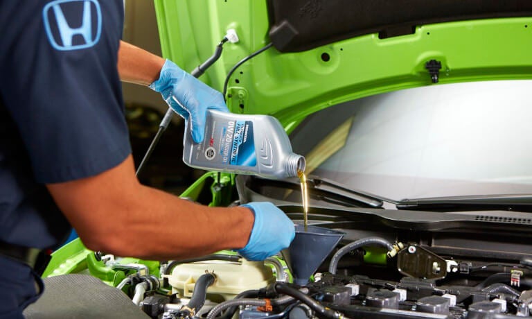 Honda technician pouring oil