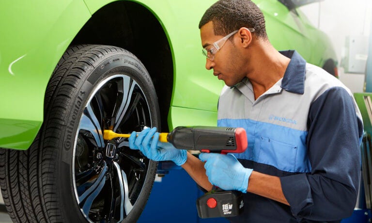 Honda technician working on a wheel